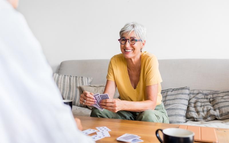 a person sitting on a couch playing cards